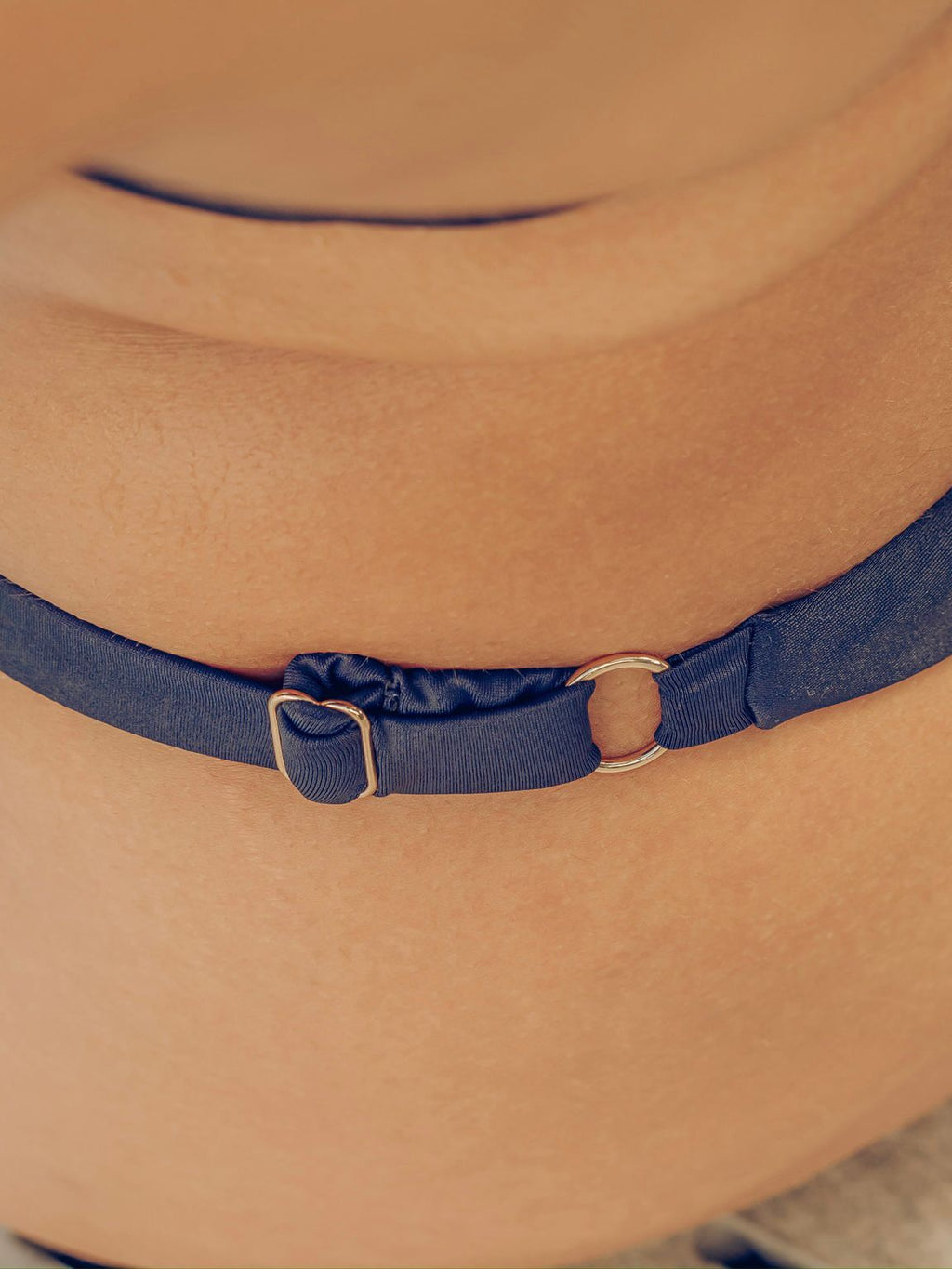 Close-up of navy blue bikini bottoms with gold details